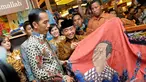 Presiden terpilih Joko Widodo melihat batik bercorak dirinya, Pasaraya Blok M, Jakarta, Kamis (2/10/2014) (Liputan6.com/Herman Zakharia)