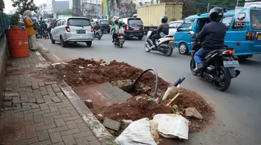 Kendaraan melintas di samping bekas galian proyek yang tidak tuntas pengerjaannya di Jalan Margonda Raya, Depok, Jawa Barat, Kamis (9/5/2019). Kondisi jalan yang diabaikan selama beberapa bulan terakhir tersebut memersempit dan mengganggu aktivitas warga. (Liputan6.com/Immanuel Antonius)