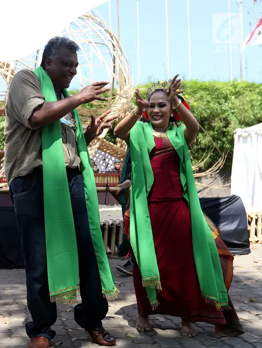 Seorang delegasi ikut menari pada pertunjukkan budaya nusantara di arena Pertemuan Tahunan IMF - World Bank 2018 di Nusa Dua Bali, Jumat (12/10). BeKraf dan LPS menyajikan beragam seni dan budaya Nusantara. (Liputan6.com/Angga Yuniar)
