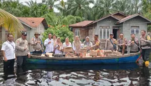 Personel Polres Rokan Hilir bersama pihak terkait membawa bantuan sembako untuk korban bencana banjir. (Liputan6.com/M Syukur)