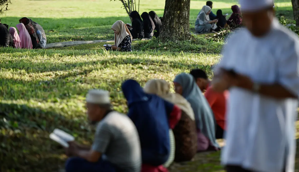 Warga berdoa saat memperingati 15 tahun musibah gempa dan tsunami di Kuburan Massal Siron, Aceh, Kamis (26/12/2019). Pada 26 Desember 2004, gempa magnitudo 9,3 memicu gelombang tsunami setinggi 30 meter dan menewaskan sekitar 170 ribu warga Aceh. (CHAIDEER MAHYUDDIN/AFP)