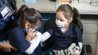 Harley Aviles, 5, (kanan) dihibur oleh saudara perempuannya sebelum menerima vaksinasi COVID-19 di Rumah Sakit Elmhurst, Queens, New York, Amerika Serikat, 5 November 2021. AS gelar vaksinasi COVID-19 untuk anak-anak berusia 5-11 tahun. (AP Photo/Eduardo Munoz Alvarez)