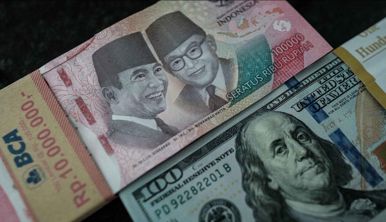 Uang kertas Rp 100.000 diletakkan berdampingan dengan uang dolar Amerika Serikat di salah satu kantor penukaran, Jakarta, Kamis pada 4 Juni 2026. (Yasuyoshi Chiba/AFP)
