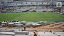 Aktivitas pekerja di dekat lapangan utama lapangan utama Jakarta International Stadium (JIS), Selasa (26/10/2021). Rumput rekomendasi FIFA ini digadang-gadang mampu digunakan mencapai 1.000 jam pertandingan dalam setahun dan memiliki daya serap air yang baik. (merdeka.com/Iqbal S Nugroho)