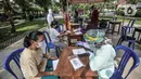 Petugas memeriksa warga saat tes usap PCR di Taman Pintar, Kayu Putih, Pulogadung, Jakarta Timur, Selasa (8/6/2021). Saat ini, RW 09 dan 10 Kelurahan Kayu Putih dalam status zona merah atau karantina wilayah sejak 4 Juni setelah 22 orang terkonfirmasi positif COVID-19. (merdeka.com/Iqbal S. Nugroho)