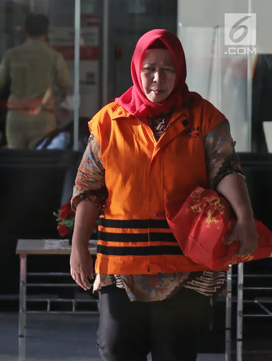 Tersangka Panitera PN Tangerang, Tuti Atika mengenakan rompi oranye seusai menjalani pemeriksaan di gedung KPK, Jakarta, Senin (2/4). Tuti kembali diperiksa sebagai saksi untuk tersangka Hakim Wahyu Widya Nurfitri. (Liputan6.com/Herman Zakharia)