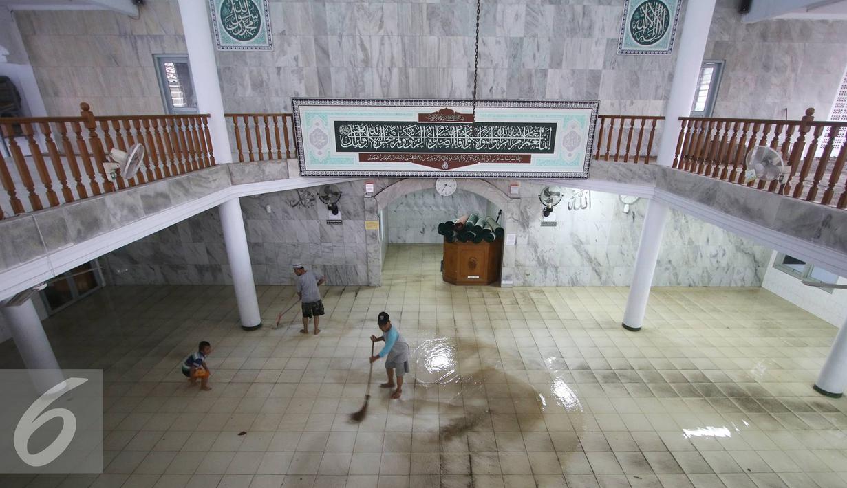 Warga bergotong royong membersihkan banjir yang menggenangi Mesjid An Nur di kawasan Pasar Minggu, Jakarta, Selasa (4/10). Banjir yang rutin menggenangi kawasan tersebut menyebabkan aktivitas warga serta ibadah terganggu. (Liputan6.com/Immanuel Antonius)