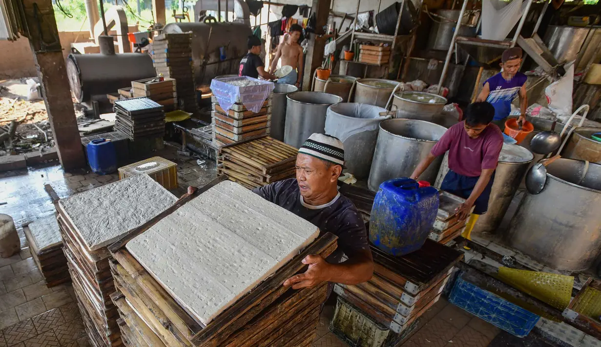 Aktivitas pekerja menyelesaikan pembuatan tahu di salah satu sentra produksi kawasan Pasir Putih, Kota Depok,  Jawa Barat, Senin (8/6/2026). (merdeka.com/Arie Basuki)