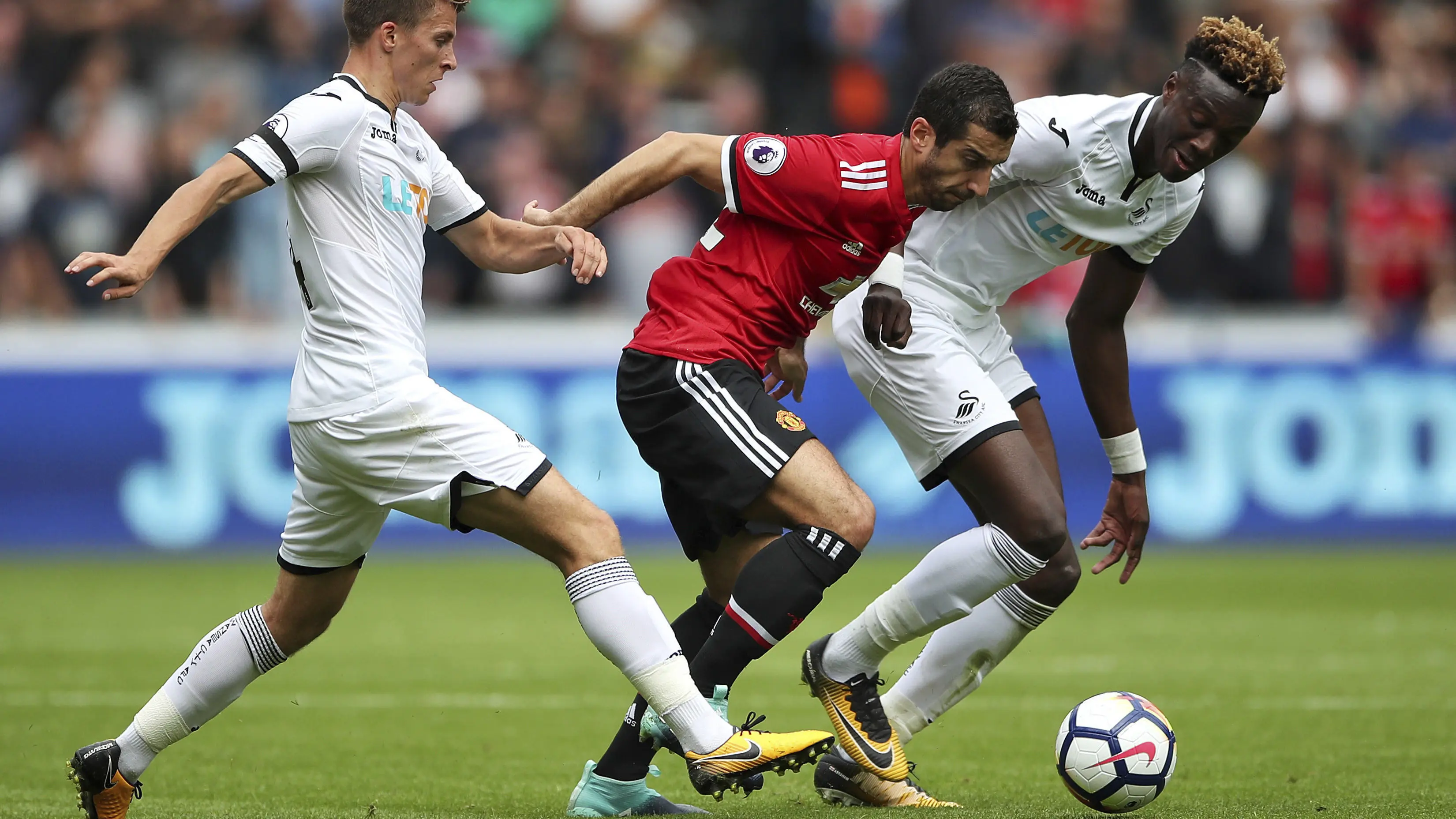 Aksi pemain Manchester United, Henrikh Mkhitaryan (tengah) melewati adangan dua pemain Swansea City pada lanjutan Premier League di Liberty Stadium, Swansea, (19/8/2017). (Nick Potts/PA via AP)