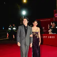 Angga dengan set jas nuansa dark grey-nya. Sementara Shenina dengan spaghetti strap dress velvet nuansa purple-gold. [@shenacinnamon/@anggayunanda]