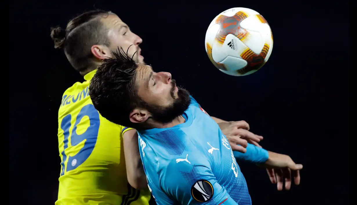 Pemain Arsenal, Olivier Giroud melompat untuk berebut bola dengan pemain BATE Borisov, Nemanja Milunovic dalam lanjutan fase Grup H Liga Europa 2017/18 di Borisov Arena, Kamis (28/9). The Gunners menang dengan skor 4-2. (AP/Sergei Grits)