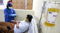 Pasien sembuh COVID-19 mendonorkan plasma darahnya di Unit Donor Darah (UDD) PMI DKI Jakarta, Rabu (23/6/2021). PMI DKI Jakarta mengajak para penyintas yang sembuh mendonorkan plasma darah konvalesen untuk membantu pasien COVID-19 yang dalam perawatan. (Liputan6.com/Faizal Fanani)