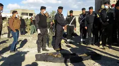 Polisi Irak berdiri di dekat jasad yang dieksekusi oleh kelompok ISIS di sebuah kuburan massal di Kota Ramadi, sebelah barat Baghdad, Selasa (26/1). Kuburan massal tersebut berisi sisa-sisa sekitar 40 jasad. (AFP/ MOADH AL-DULAIMI)