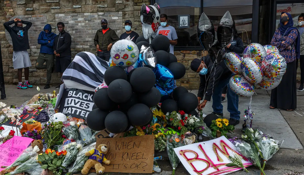 Bunga dan balon memenuhi lokasi kematian George Floyd oleh polisi di Minneapolis, Minnesota, Amerika Serikat, Rabu (27/5/2020). Unjuk rasa damai berubah menjadi kerusuhan setelah polisi menembaki mereka dengan gas air mata dan peluru busa. (Kerem Yucel/AFP)
