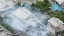 Asap mengepul dari sebuah rumah usai gempa bumi menghantam Takatsuki, Osaka, Jepang, Senin (18/6). Gempa bumi dilaporkan terjadi sebelum jam 08.00 pagi saat penduduk setempat sedang menuju tempat kerja. (Yohei Nishimura/Kyodo News via AP)