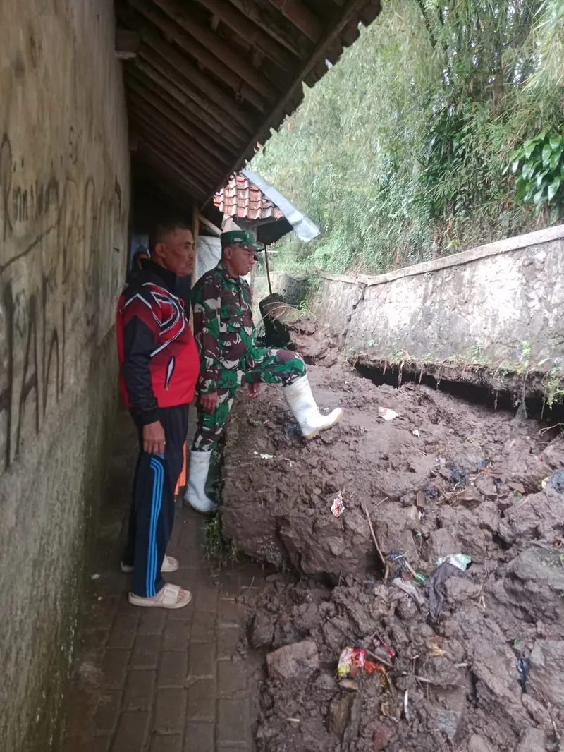 Hantaman material longsor menyebabkan Tembok Penahan Tanah (TPT) sepanjang 20 meter dengan tinggi 2 meter di Kampung Cigadog, Desa Padamukti. Camat Pasirwangi ambruk. (Liputan6.com/Jayadi Supriadin)