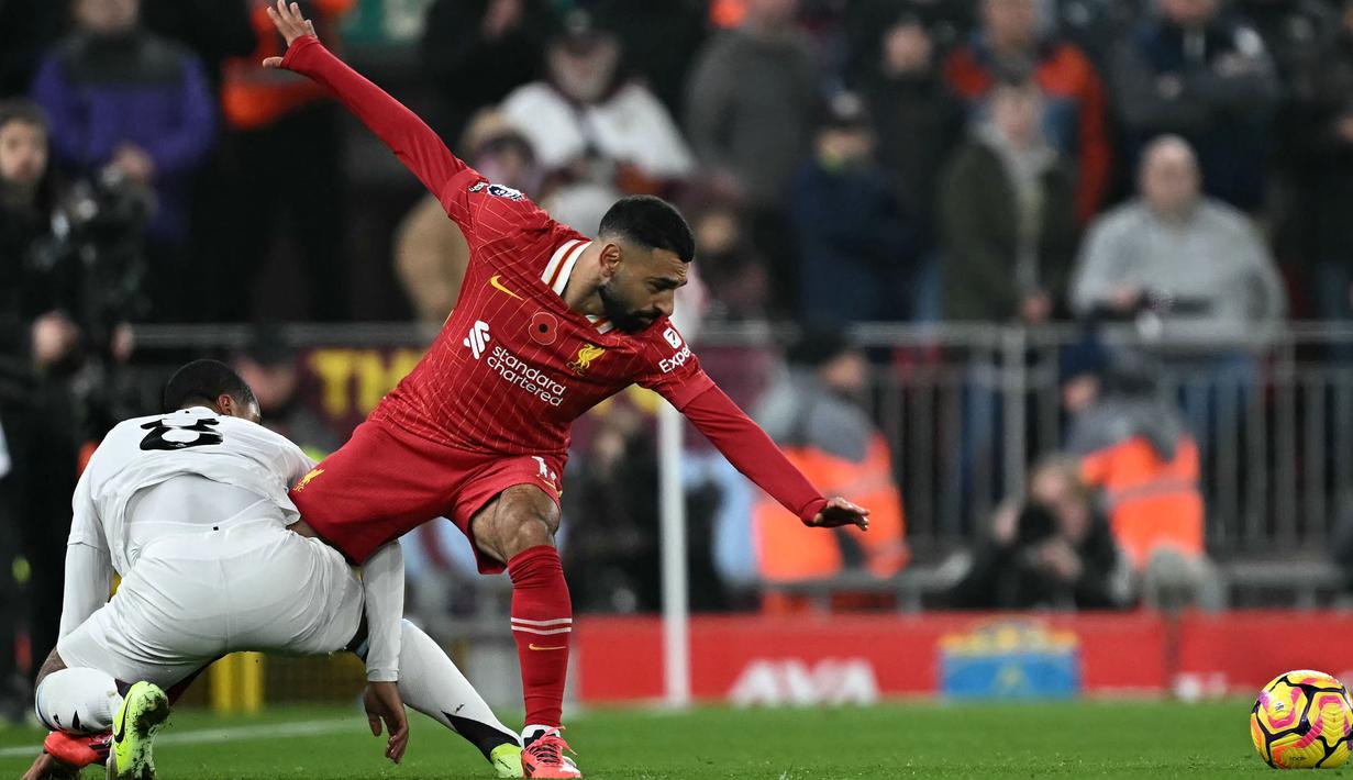 Pemain Liverpool, Mohamed Salah (kanan) berusaha melepaskan diri dari penjagaan pemain Aston Villa, Youri Tielemans pada laga lanjutan Liga Inggris 2024/2025 yang berlangsung di Anfield, Liverpool, Inggris, Minggu (10/11/2024) WIB. (AFP/Paul Ellis)