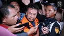 Bupati Jombang Nyono Suharli Wihandoko (tengah) menjawab pertanyaan usai menjalani pemeriksaan di Gedung KPK, Jakarta, Minggu (4/2). Nyono menjadi tersangka suap perizinan pengurusan jabatan di Pemkab Jombang. (Liputan6.com/Helmi Fithriansyah)