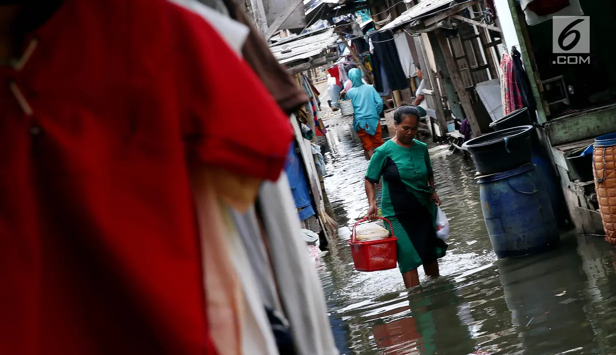 Warga beraktivitas terjadi banjir rob yang menggenangi perkampungan/rumah mereka di Muara Angke, Jakarta, Kamis (4/1). Menurut pihak setempat, masuknya air laut memang selalu terjadi saat pasang, terutama di purnama. (Liputan6.com/JohanTallo)