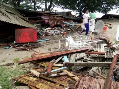Seorang pria mencari barang-barang dari rumahnya yang rusak setelah tsunami menerjang Pantai Carita, di perairan Banten, Minggu (23/12). Tsunami menerjang beberapa daerah di sekitar Selat Sunda pada Sabtu 22 Desember 2018 malam. (SEMI / AFP)