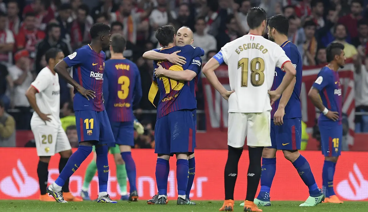 Kapten Barcelona, Andres Iniesta, memeluk Lionel Messi usai menjuarai Copa del Rey dengan mengalahkan Sevilla di stadion Wanda Metropolitano, Madrid, Minggu (22/4/2018). Barcelona menang 5-0 atas Sevilla. (AFP/Lluis Gene)