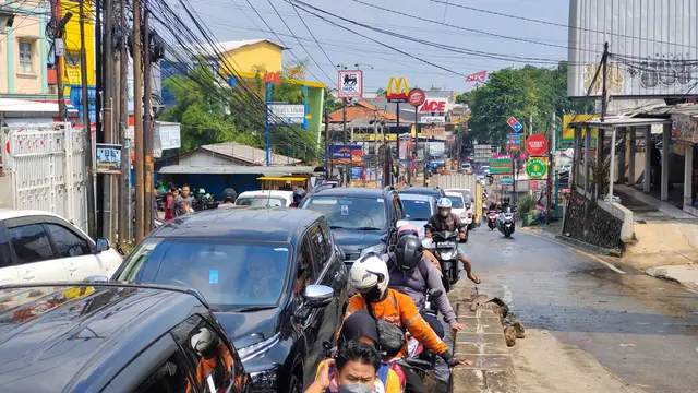 Kemacetan lalu lintas akibat dampak luapan air Kali Licin di Jalan Raya Sawangan, Kota Depok.