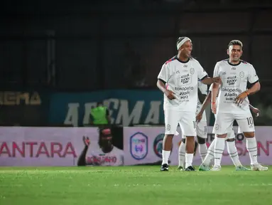 Bersama Rans Nusantara FC, mantan pemain Barcelona, Ronaldinho (kiri) melakukan duet dengan Cristian Gonzales dalam pertandingan pertama Trofeo Ronaldinho melawan Persik Kediri. (Bola.com/Iwan Setiawan)