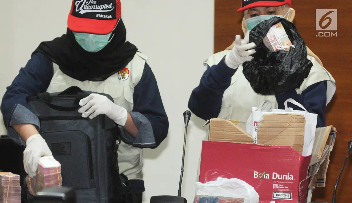 Penyidik menunjukan barang bukti uang Rp1,5 M di gedung KPK, Jakarta, (12/12). KPK menetapkan tersangka Bupati Cianjur Irvan Rivano Muchtar, Kadisdik Cecep Sobandi, Kabid SMP Rosidin dan kakak ipar Bupati Tubagus Cepy Sethiady. (merdeka.com/Dwi Narwoko)
