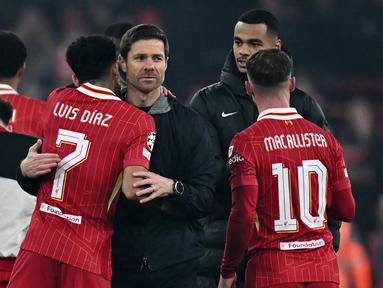 Pelatih Bayer Leverkusen, Xabi Alonso (tengah) berpelukan dengan pemain Liverpool, Luis Diaz setelah pertandingan lanjutan Liga Champions 2024/2025 yang berlangsung di Anfield, Liverpool, Inggris, Rabu (06/11/2024) dini hari WIB. (AFP/Paul Ellis)
