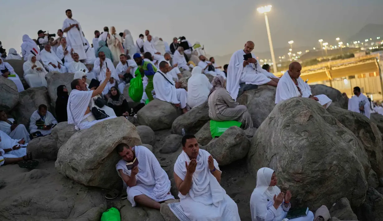 Umat Muslim berdoa di puncak bukit berbatu yang dikenal sebagai Jabal Rahmah atau Gunung Rahmat, di Dataran Arafah, selama ibadah haji tahunan di dekat kota suci Mekah, Arab Saudi, Selasa 26 Mei 2026. (AP Photo/Altaf Qadri)