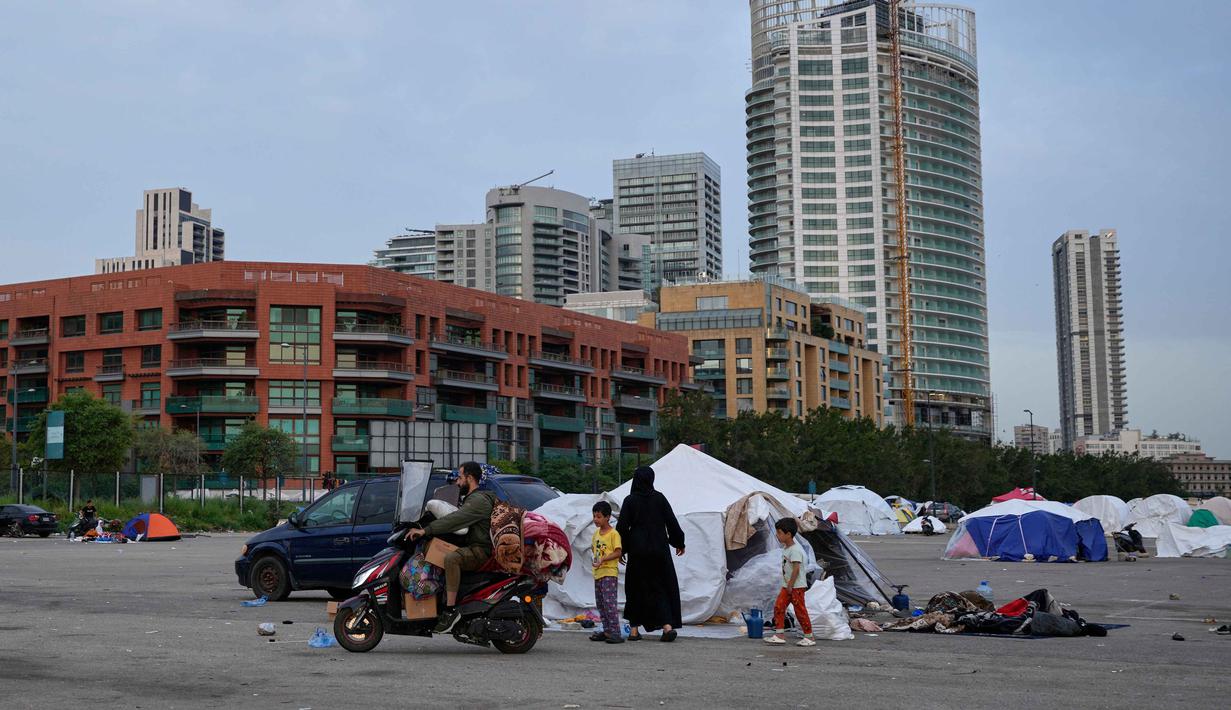 Seorang pria pengungsi dengan barang-barang keluarganya di atas skuter bersiap untuk kembali ke rumah setelah gencatan senjata antara Hizbullah dan Israel di Beirut, Lebanon, Jumat 17 April 2026. (AP Photo/Hussein Malla)