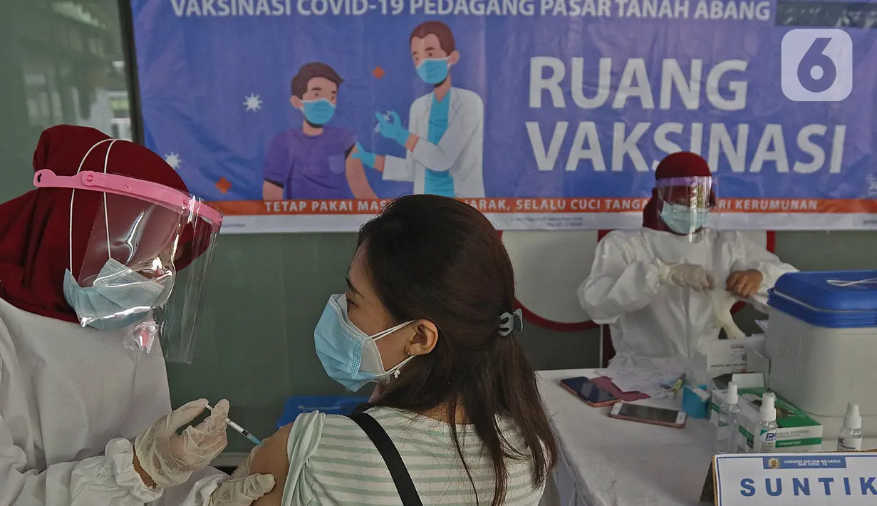 Seorang wanita menjalani vaksinasi COVID-19 di Pasar Tanah Abang Blok A, Jakarta, Rabu (17/2/2021). Vaksinasi COVID-19 tahap kedua yang diberikan untuk pekerja publik dan lansia itu dimulai dari pedagang Pasar Tanah Abang di blok A, B, F, dan G. (Liputan6.com/Herman Zakharia)