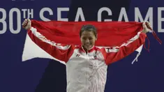 Lifter Aisyah Windy mengibarkan bendera saat naik podium usai mendapatkan medali emas SEA Games 2019 cabang angkat besi nomor 49 kg di Stadion Rizal Memorial, Manila, Minggu (1/12). Dirinya meraih emas dengan total angkatan 104 kg. (Bola.com/M Iqbal Ichsa