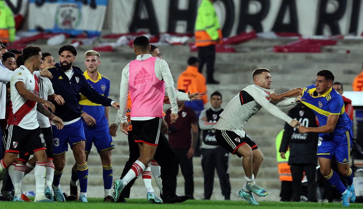 Pemain River Plate berusaha menenangkan pemain Boca Junior, Miguel Merentiel (kanan) setelah insiden keributan yang terjadi dalam pertandingan Argentine Professional Football League Tournament 2023 yang berlangsung di El Monumental stadium, Senin (8/5/2023) pagi WIB. (AFP/Alejandro Pagni)