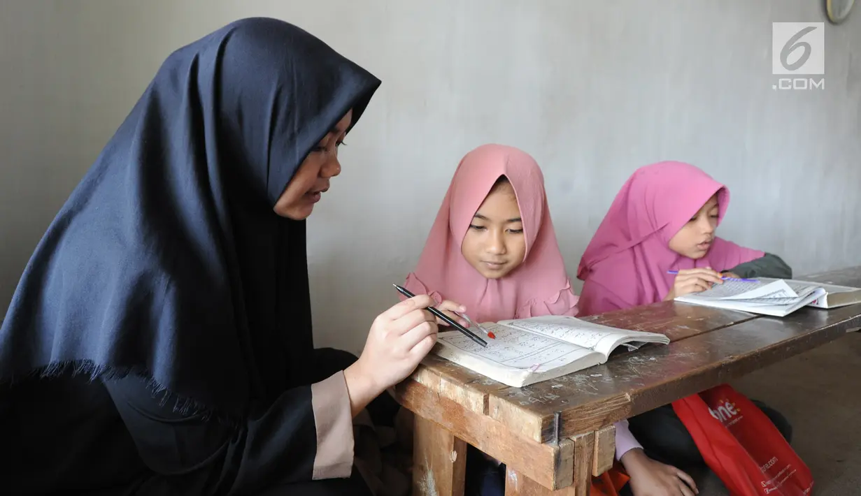 Guru mengajari santri mengaji di Pondok Pesantren Almiizan, Kabupaten Bogor, Jawa Barat, Senin, (20/5/2019). Al Quran mini di pasentren ini merupakan barang bersejarah peninggalan Pangeran Wijaya Kusuma salah satu pahlawan yang berjuang pada zaman kolonial Belanda. (merdeka.com/Arie Basuki)