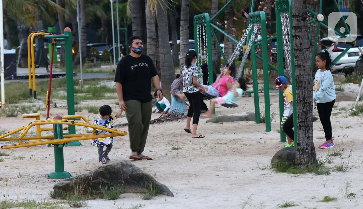 Pengunjung bersama anak-anak menikmati suasana pantai di Taman Impian Jaya Ancol, Jakarta, Kamis (29/10/2020). Libur panjang di masa pemberlakuan PSBB transisi Jakarta dimanfaatkan warga untuk mengunjungi lokasi-lokasi wiisata. (Liputan6.com/Helmi Fithriansyah)