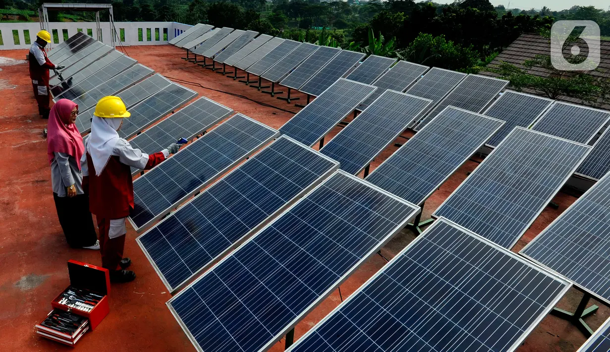 Seorang guru mengajarkan praktek perawatan solar panel kepada siswa kompetensi keahlian Teknik Energi Surya Hidro dan Angin (TESHA) di SMK Negeri 1 Kemang Bogor, Jawa Barat, Kamis (19/5/2022). Solar panel teserbut selain sebagai media pembelajaran siswa juga menghasilkan energi listrik yang digunakan untuk kebutuhan pasokan listrik di lab sekolah tersebut. (merdeka.com/Arie Basuki)