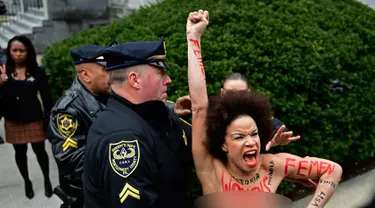 Pengunjuk rasa wanita mendatangi sidang kekerasan seksual komedian Bill Cosby di Gedung Pengadilan Montgomery, Pennsylvania, Amerika Serikat, Senin (9/4). Wanita itu ditahan karena tampil topless. (AP Photo/Corey Perrine)