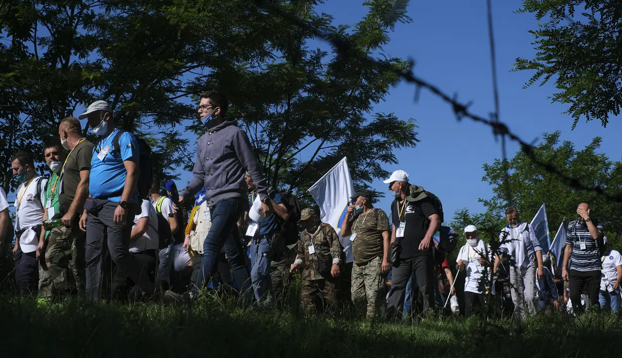 Rakyat Bosnia berjalan melalui daerah pegunungan dekat Crni Vrh saat memperingati 25 tahun pembantaian Srebrenica di Bosnia, Rabu (8/7/2020). Acara yang diikuti beberapa korban selamat dari pembantaian tersebut mengambil rute saat mereka melarikan diri dari pasukan Serbia. (AP Photo/Kemal Softic)
