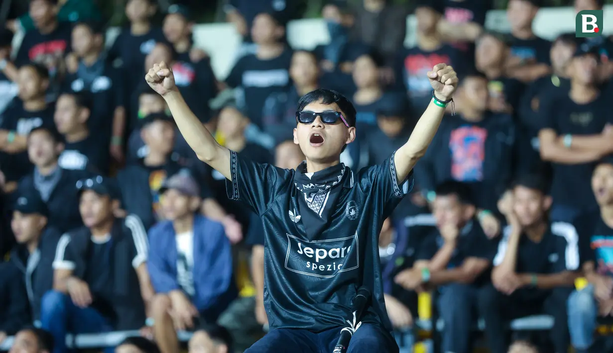 Suporter Persijap Jepara bernyanyi saat pertandingan uji coba melawan Persipura Jayapura di Stadion Gelora Bumi Kartini (GBK) Jepara, Sabtu (26/7/2025). (Bola.com/M. Iqbal Ichsan)