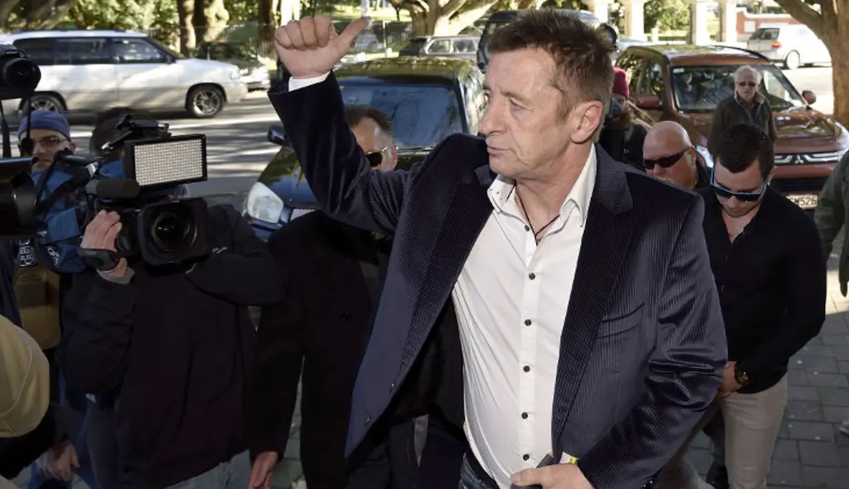 Mantan drummer AC/DC Phil Rudd mengacungkan jempol saat tiba di pengadilan untuk menghadapi sidang pembacaan vonis terhadap ririnya, Tauranga, Selandia Baru, Kamis (9/7/2015). (AFP/Marty Melville)