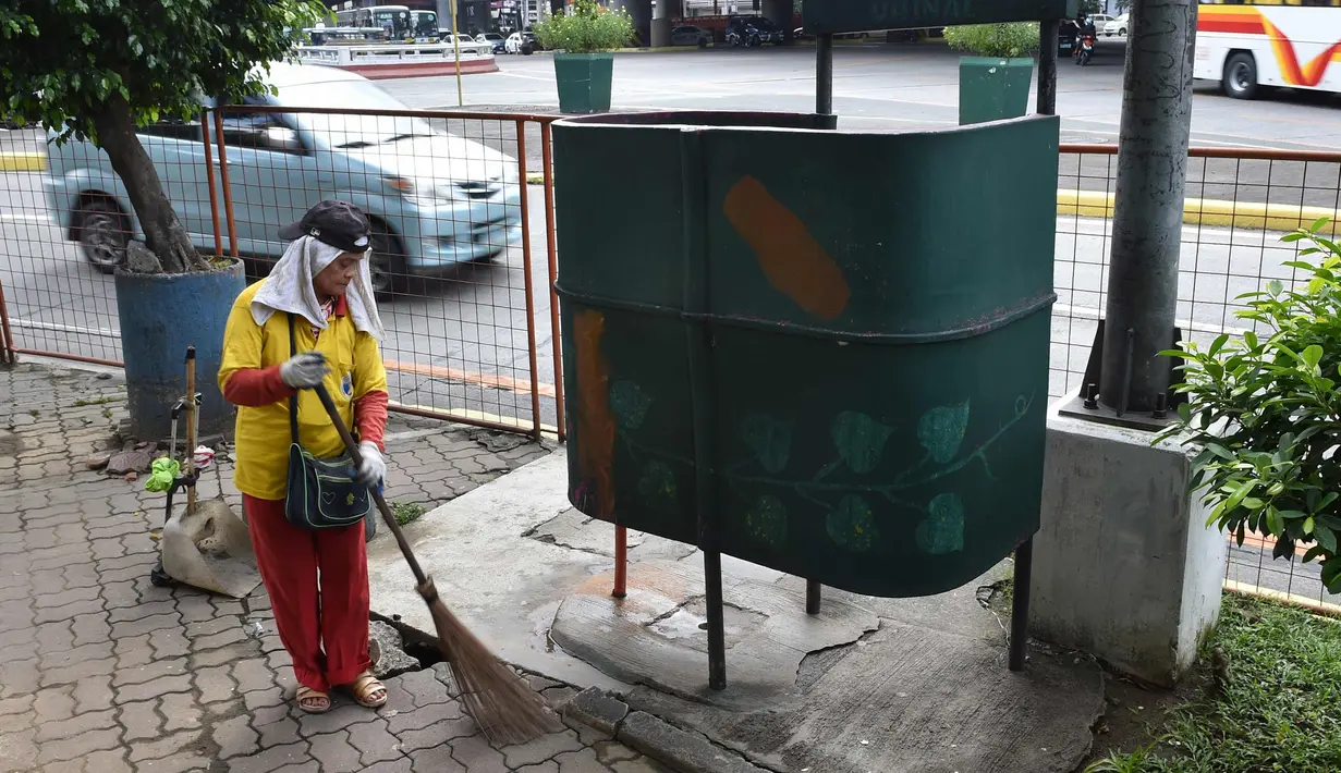 Petugas kebersihan berada di dekat toilet umum di sepanjang jalan utama di Manila, Filipina, (24/11). Tidak seperti umumnya, toilet di Filipina ini dibangun di bawah jembatan dan berada di tempat terbuka. (AFP Photo/Ted Aljibe)