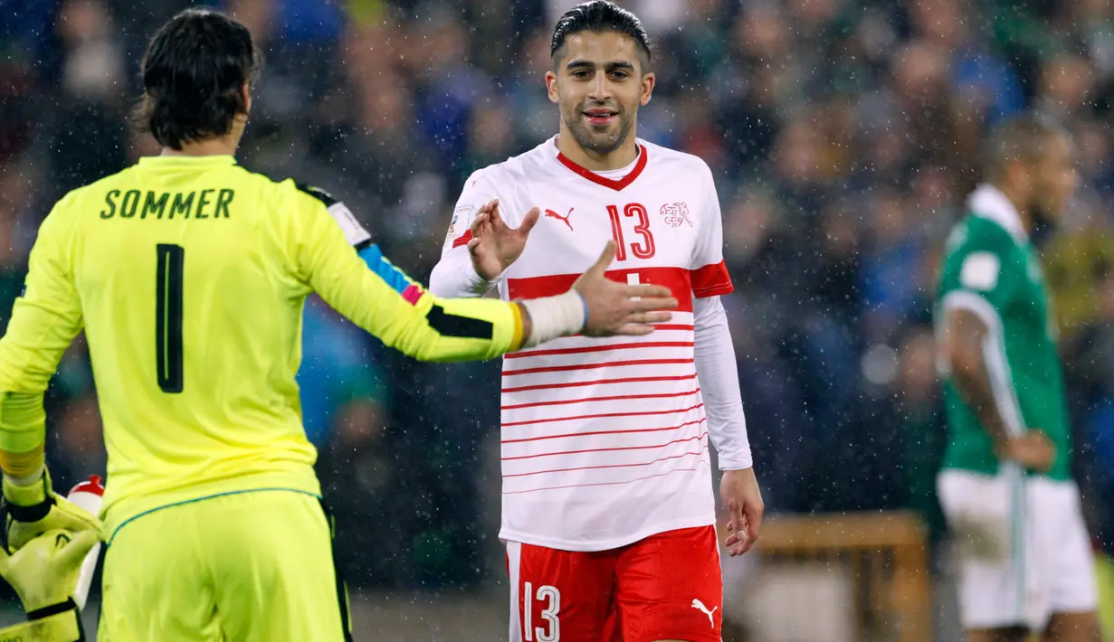 Kiper Swiss, Yann Sommer dan rekan timnya, Ricardo Rodriguez merayakan kemenangan atas Irlandia Utara pada leg pertama playoff Piala Dunia 2018 di Windsor Park, Jumat (10/11). Bermain di kandang lawan, Swiss meraih kemenangan tipis 1-0 (AP/Peter Morrison)