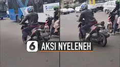 Pria itu nampak tidak mau memijakkan kakinya di aspal jalan.