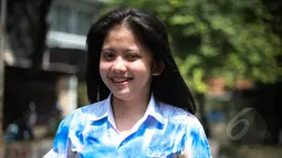 Seorang siswi mengenakan seragam yang penuh coretan usai mengikuti Ujian Nasional (UN) di Jakarta, Kamis (16/4/2015). Aksi coret seragam tersebut merupakan tradisi para pelajar sebagai bentuk kegembiraan usai mengikuti UN. (Liputan6.com/Faizal Fanani)
