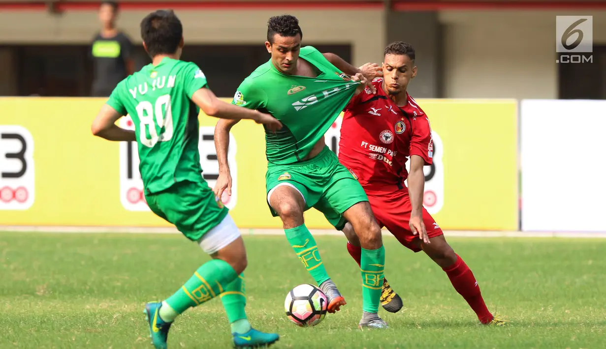 Bek Bhayangkara FC, Otavio Dutra (tengah) berebut bola dengan Cassio Fransisco de Jesus (Semen Padang) di lanjutan Liga 1 Indonesia di Stadion Patriot Candrabhaga, Bekasi, Sabtu (20/5). Bhayangkara FC unggul 1-0. (Liputan6.com/Helmi Fithriansyah)