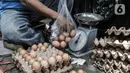 Pekerja menimbang telur yang dipesan warga saat Gelar Pangan Murah di Pasar Tebet Barat, Jakarta, Rabu (23/12/2020). Telur ayam pada Gelar Pangan Murah ini dijual dengan paket Rp24.000 per kilogram dan Rp45.000 per tray atau kotak. (merdeka.com/Iqbal S. Nugroho)