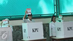 Calon Wakil Gubernur (Cawagub) DKI Jakarta, Sandiaga Uno bersama istri dan anaknya menunujukan kertas suara sebelum menyoblos dalam Pilkada Putaran kedua di TPS 01, Kebayoran Baru, Jakarta, Rabu (19/4). (Liputan6.com/Helmi Afandi)