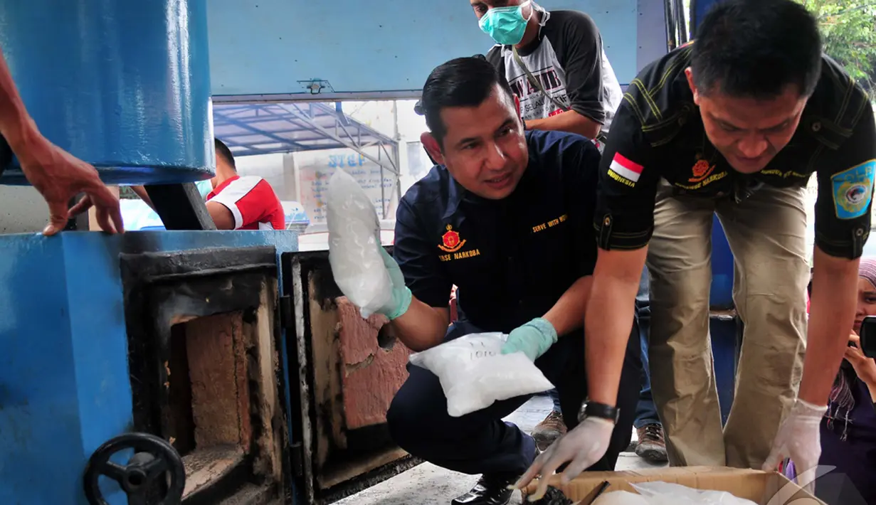 Petugas kepolisian memasukkan sabu kedalam tungku untuk dimusnahkan, Jakarta Timur, Selasa (14/10/2014) (Liputan6.com/Johan Tallo)