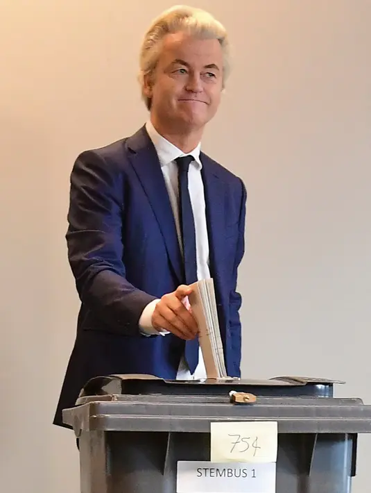 Politikus anti-Islam Belanda Geert Wilders memasukkan surat suara ke kotak suara saat pemilihan umum Belanda di sebuah Tempat Pemungutan Suara (TPS) di Den Haag, Rabu (15/3). Kotak suara yang tersedia terbuat dari tempat sampah. (Emmanuel DUNAND/AFP)